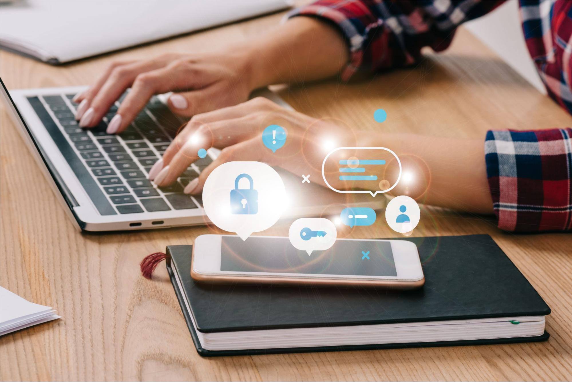 Icons floating above a cell phone and next to a person using a laptop.&nbsp;