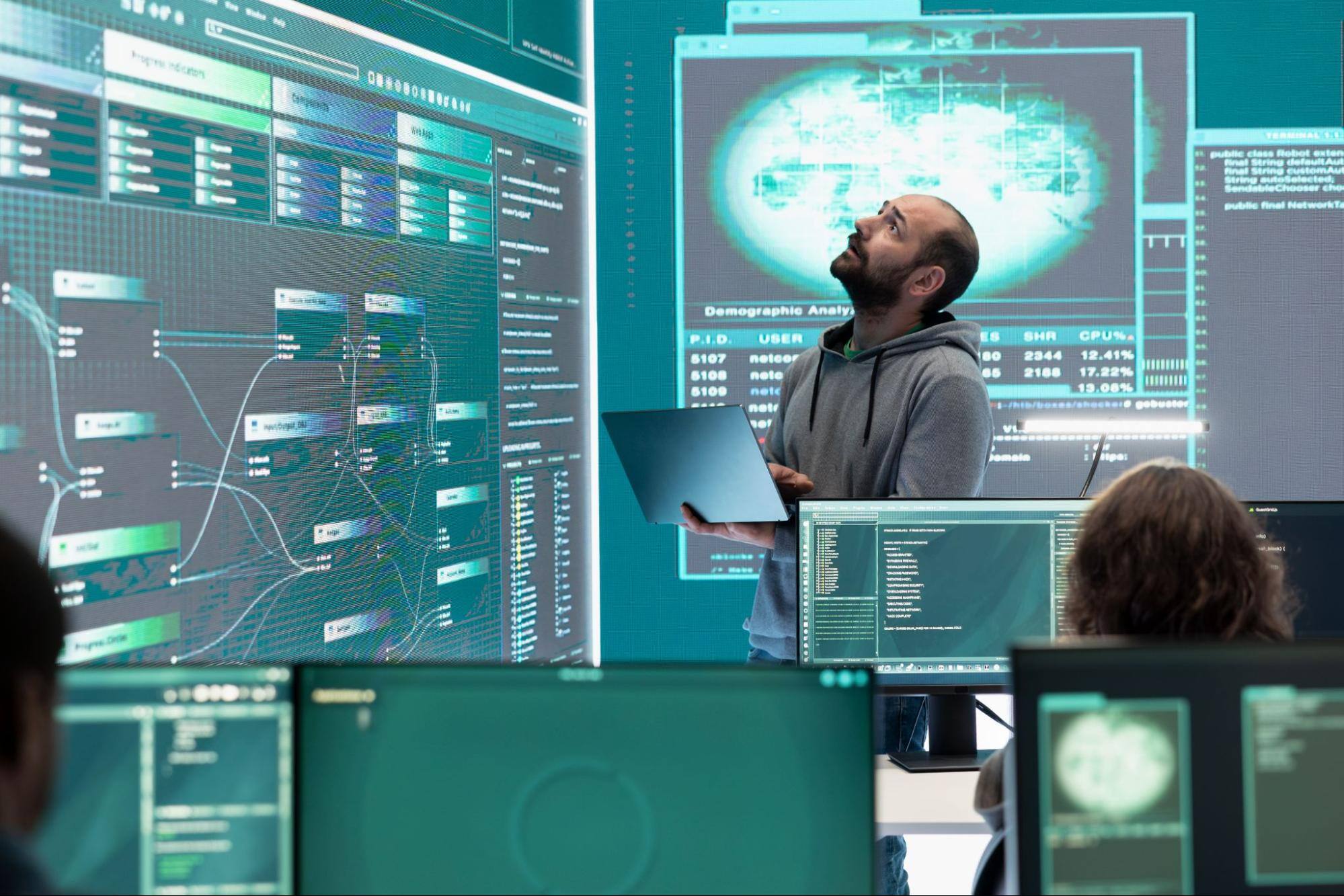 A cybersecurity specialist surrounded by multiple screens monitors data integration platform trends in a government agency's surveillance center.