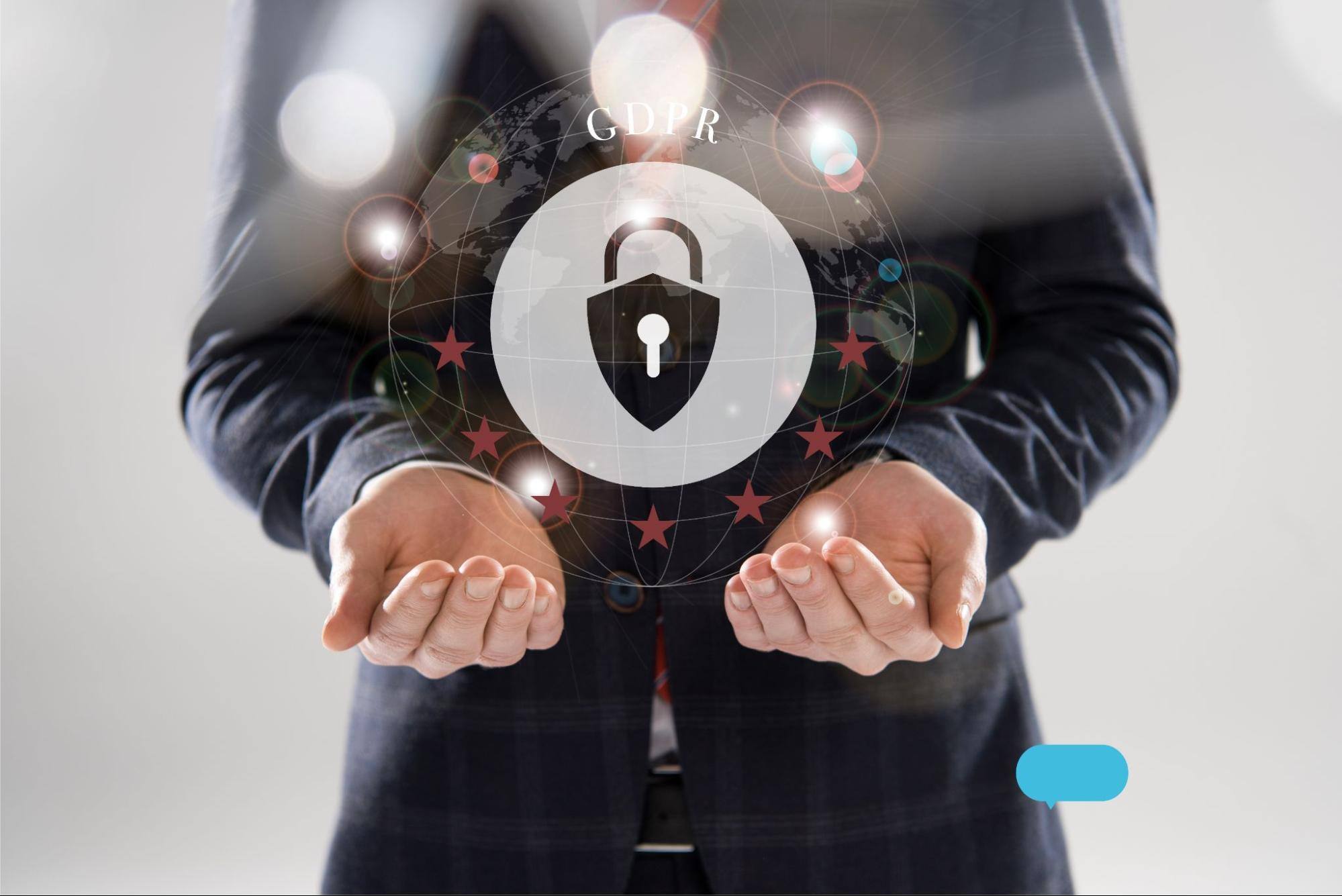 A cropped view of a businessman in a suit with outstretched hands, holding GDPR letters and a lock illustration symbolizing data protection and compliance.