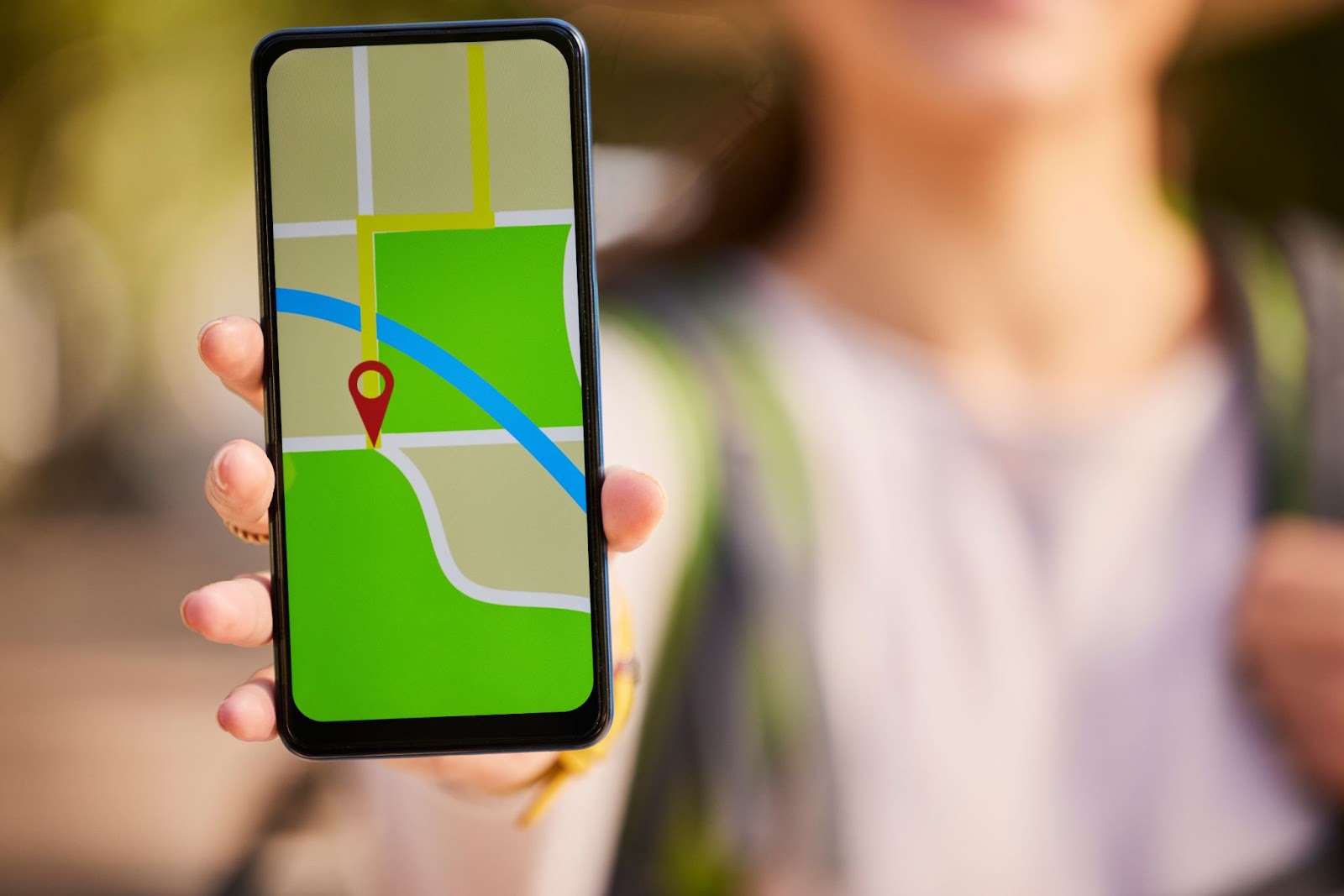 A woman is holding a phone and showing a GPS transmission